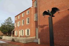 Raven statue beside a historic three-story brick home of Edgar Allan Poe in Pennsylvania