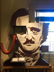 Museum exhibit featuring a book and a large cutout of Edgar Allan Poe's head at Edgar Allan Poe National Historic Site in Pennsylvania