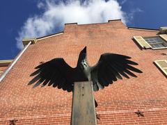 Statue of a raven spreading its wings outside a brick building at Edgar Allan Poe National Historic Site Pennsylvania