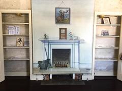 Fireplace area between two almost empty bookshelves at Edgar Allan Poe National Historic Site in Pennsylvania