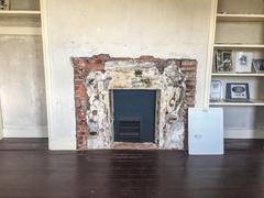 Fireplace between two nearly empty bookshelves at Edgar Allan Poe National Historic Site in Pennsylvania