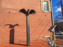 Solar panel near a statue of a raven outside a brick building at Edgar Allan Poe National Historic Site