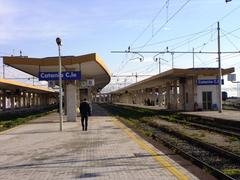Train at Catania railway station in Italy with historic city architecture in the background