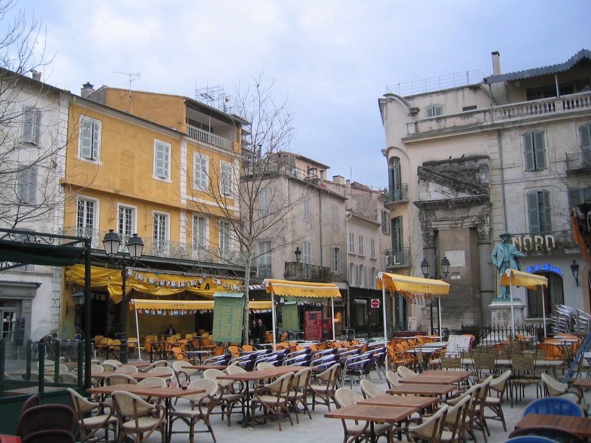 Historic Place du Forum square in Arles, France with traditional buildings and outdoor cafes