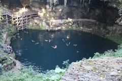 Cenote Zaci natural swimming hole with turquoise water surrounded by rocky walls and lush greenery