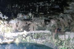 Cenote Zaci natural sinkhole with clear water surrounded by rocky cliffs and lush vegetation