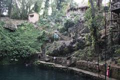Cenote Zaci natural sinkhole with clear turquoise water surrounded by rocky walls and green vegetation