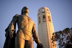 Coit Memorial Tower in San Francisco surrounded by green trees against a clear blue sky