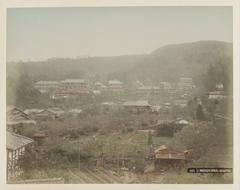 Colored albumen print of a village view in Maruyama near Kyoto with mountainous backdrop from ca. 1870-1900