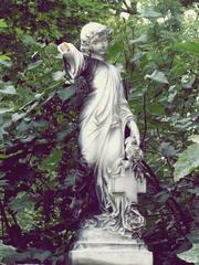 Statue with broken arm on a gravestone at Central Cemetery in Brno