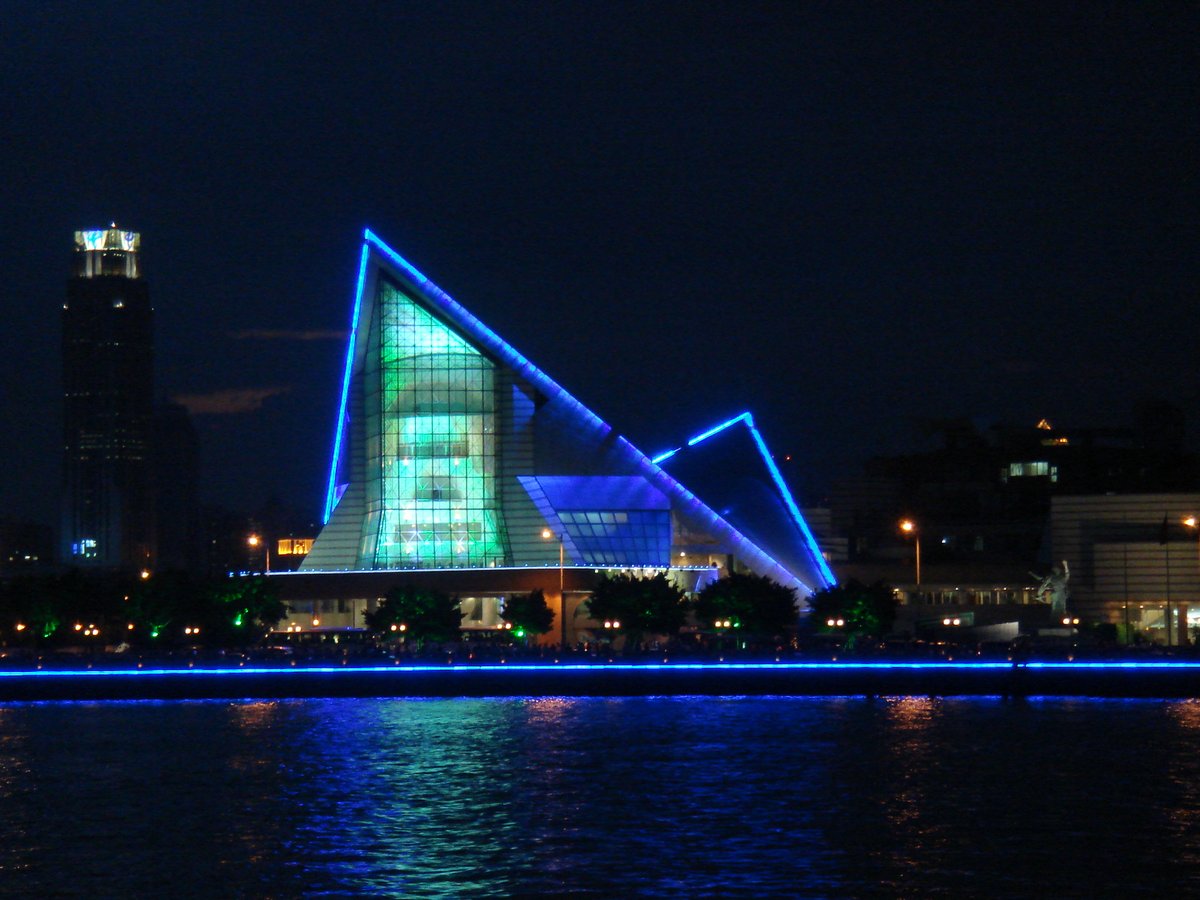 Xinghai Concert Hall exterior at dusk with modern curved glass architecture