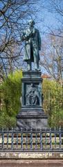 Uhlanddenkmal statue in spring 2021 surrounded by trees in bloom in Tübingen