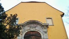 Interior view of Kiscelli Museum with historic paintings and ornate wooden beams