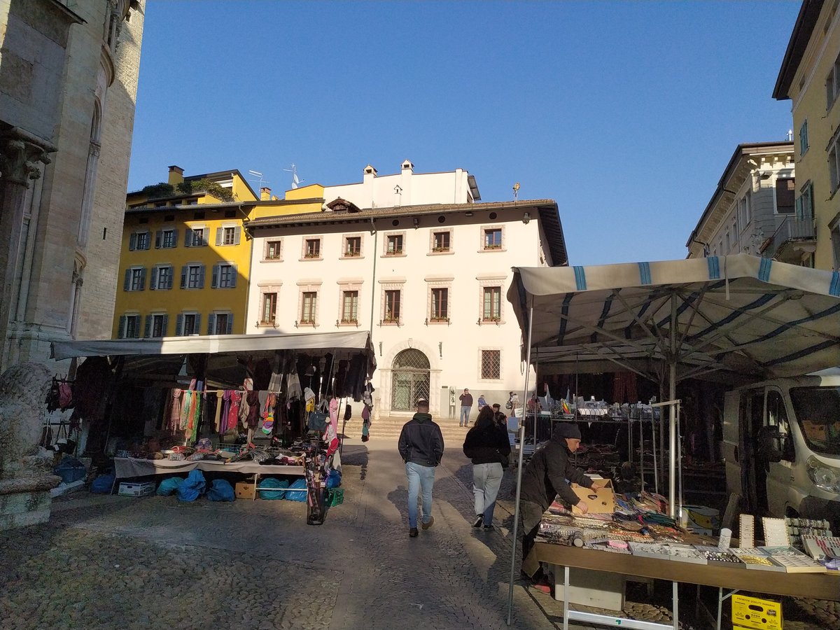 Outdoor market at Piazza Adamo D'Arogno in Trento with Palazzo Calepini in the background