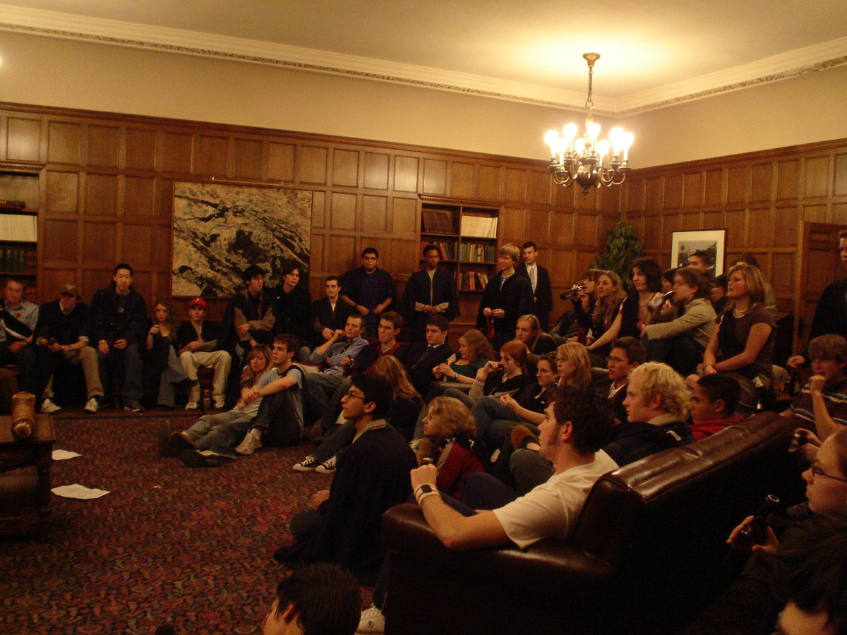 Audience watching a political debate on stage with a speaker at the podium