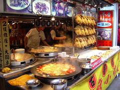 Traditional street view of Shenkeng Old Street in Taipei with vendors showcasing local foods including famous smelling bean curd