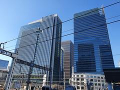Shinkansen bullet train platform at Tokyo Station with white and green trains and passengers on the platform