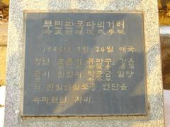 Keijo Public Hall Incident Monument surrounded by flowers and greenery