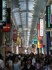 Busy shopping street in Osaka with colorful shop signs and crowds