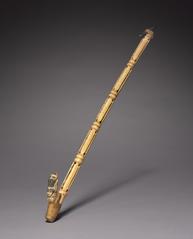 Ancient carved spear thrower with skeletal figure and severed head design