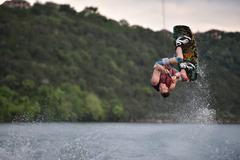 Male wakeboarder performing a jump on Lake Austin