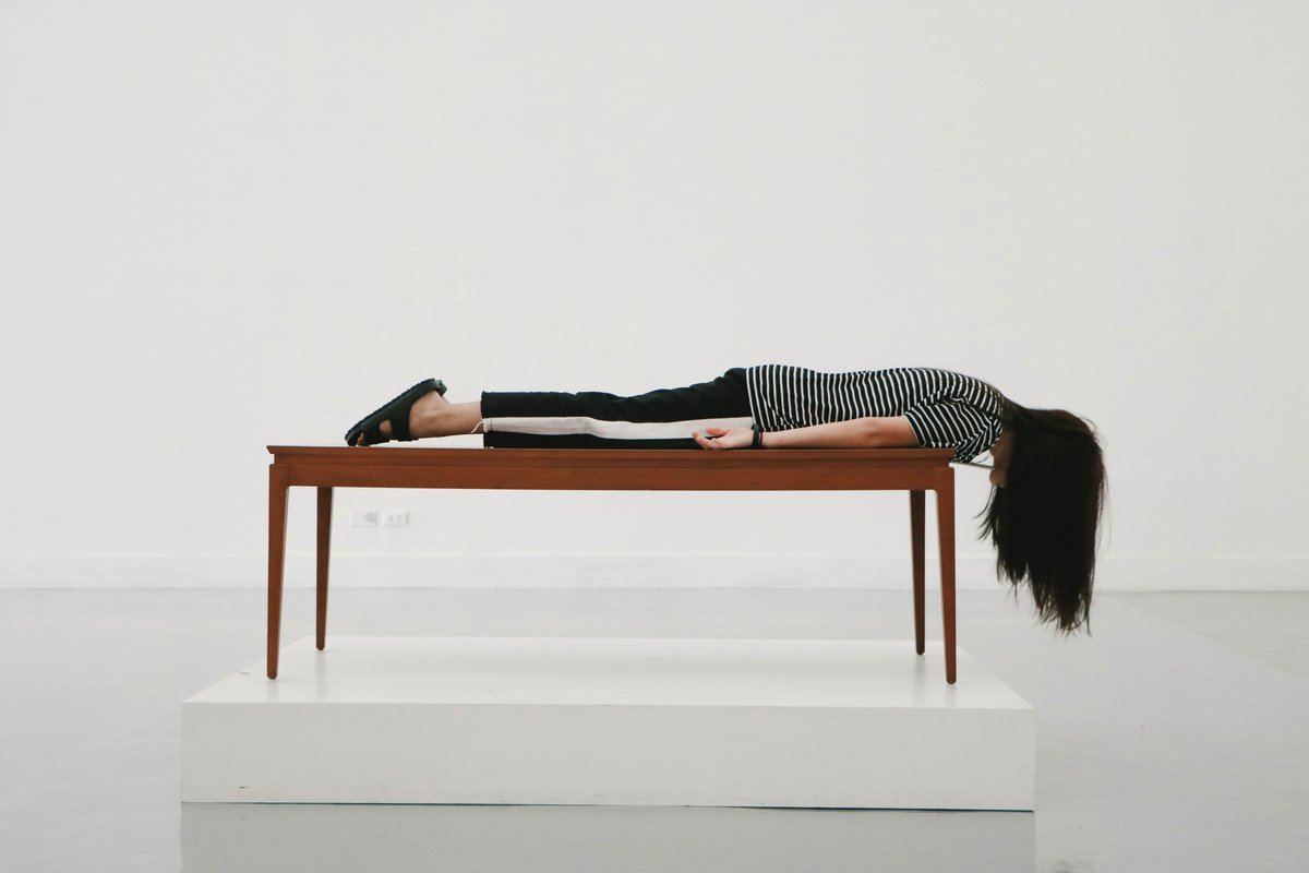 Woman lying face down on a table at Bangkok Art and Culture Centre