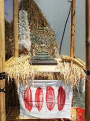 Gautama Buddha statue with disciples Moggallana and Sariputta surrounded by rice ears and straws at Bangkok Art and Culture Centre