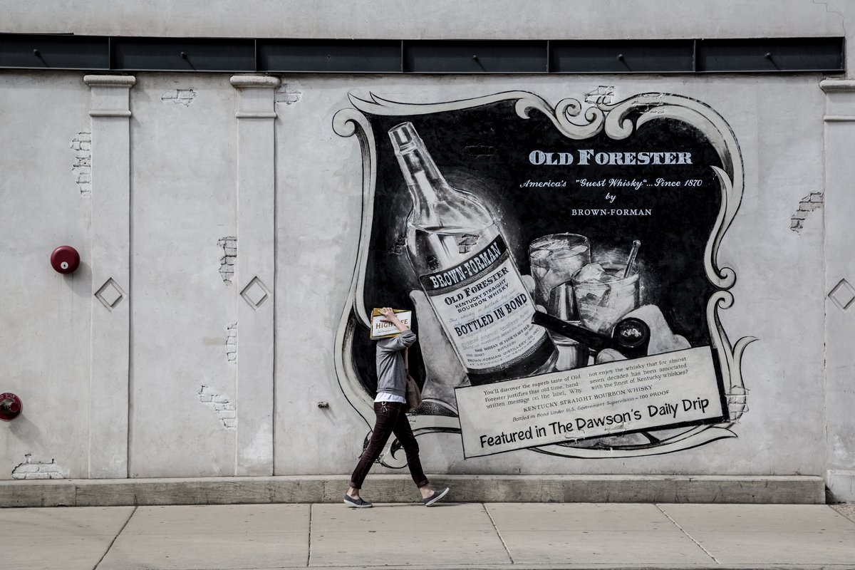 Person walking by a colorful poster on a city wall in Central Chicago USA