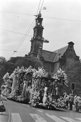 Float parade at Aalsmeerse Bloemencorso 1980 with decorated wagons in front of Westertoren, Amsterdam