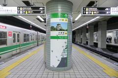 Platforms 1 and 2 of Morinomiya Station on the Osaka Metro Chuo Line with passengers and signage
