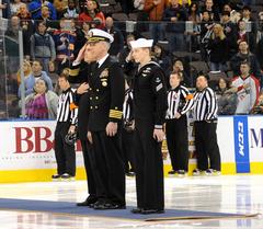Capt. Karl O. Thomas and Seaman Alex Penegar saluting during national anthem at Norfolk Scope arena