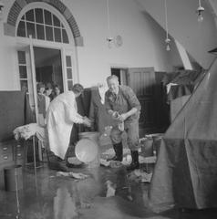 Fire damages roof of Tropenmuseum in Amsterdam, 1965, museum staff cleaning water