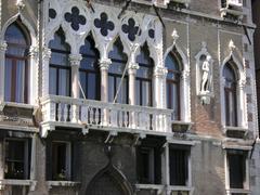 Balcony of Palazzo Querini in Venice with ornate iron railing and historic windows
