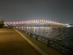 Sabarmati riverfront and Atal Pedestrian Bridge illuminated at night with colorful lights