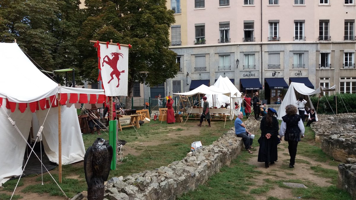 Crowded Place Saint Jean in Lyon during Lyon 2021 animations with colorful flags and festive atmosphere