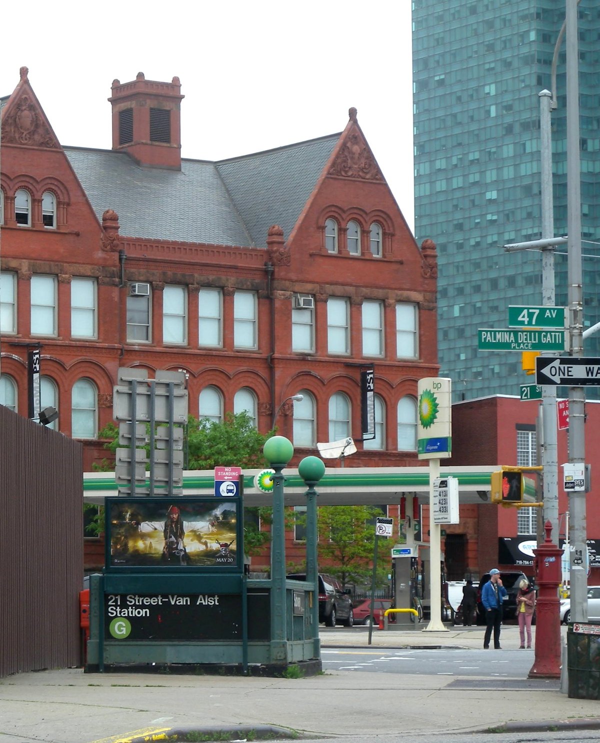 Jackson Avenue entrance of Van Alst G station with PS 1 school building behind on a cloudy day