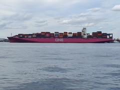 Ocean Network Express container ship entering Tokyo harbor with city skyline in the background