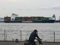 Cargo ship at the entrance of Tokyo port with city skyline in the background