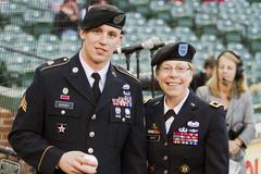 Sgt. Ryan Barger throwing the ceremonial first pitch at a Baltimore Orioles game during Army Reserve's 105th birthday celebration with Brig. Gen. Tammy Smith