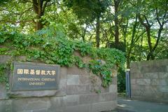 International Christian University main gate entrance with trees and clear sky