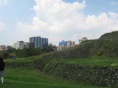 View of Cuicuilco pyramid ruins with modern buildings of Villa Olimpica neighborhood in Mexico City in background