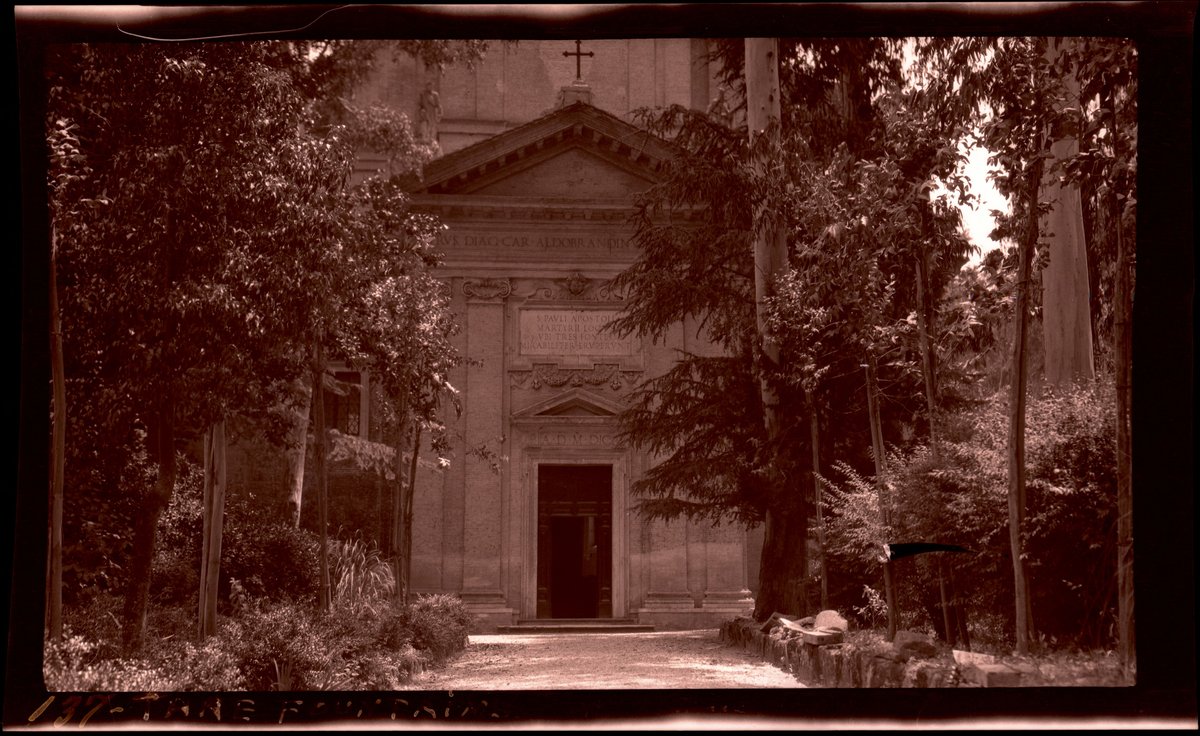 Trees and vegetation-lined path leading to the front entrance of the Church of Saint Paul at the Three Fountains in Rome
