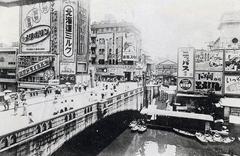 Ebisubashi bridge in Osaka city during 1951 with people and traditional buildings