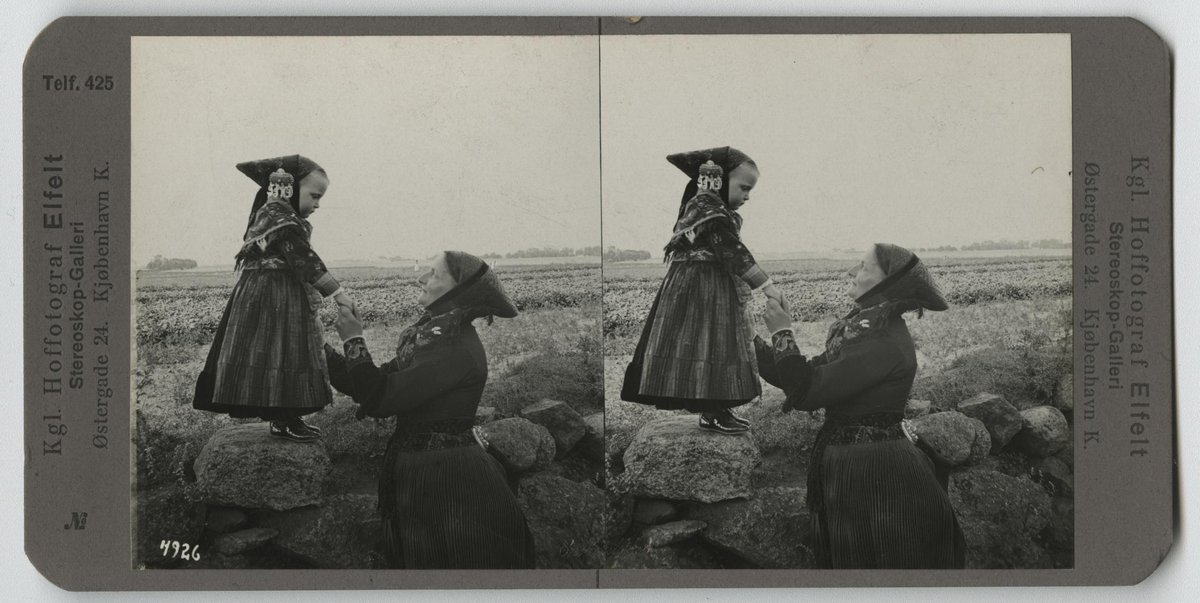 Black and white historic photograph of a woman and a girl in traditional Danish national costumes from Amager in 1904