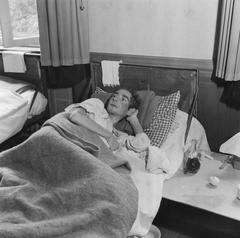 Man lying on bed in Bergen-Belsen concentration camp during repatriation 1945