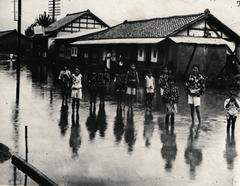 Children playing on water-covered road during heavy rain in August 1925