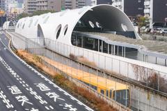 Exterior view of Astram Line's Shin-Hakushima Station with yellow Astram Line train and underground tracks