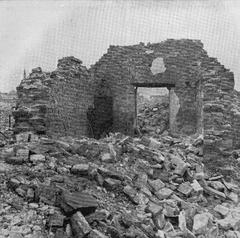 Ruins of Pawiak prison cells in Warsaw with entrance doors featuring peepholes