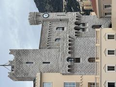 La Palais Princier clock tower in Monaco with detailed architecture and clear blue sky