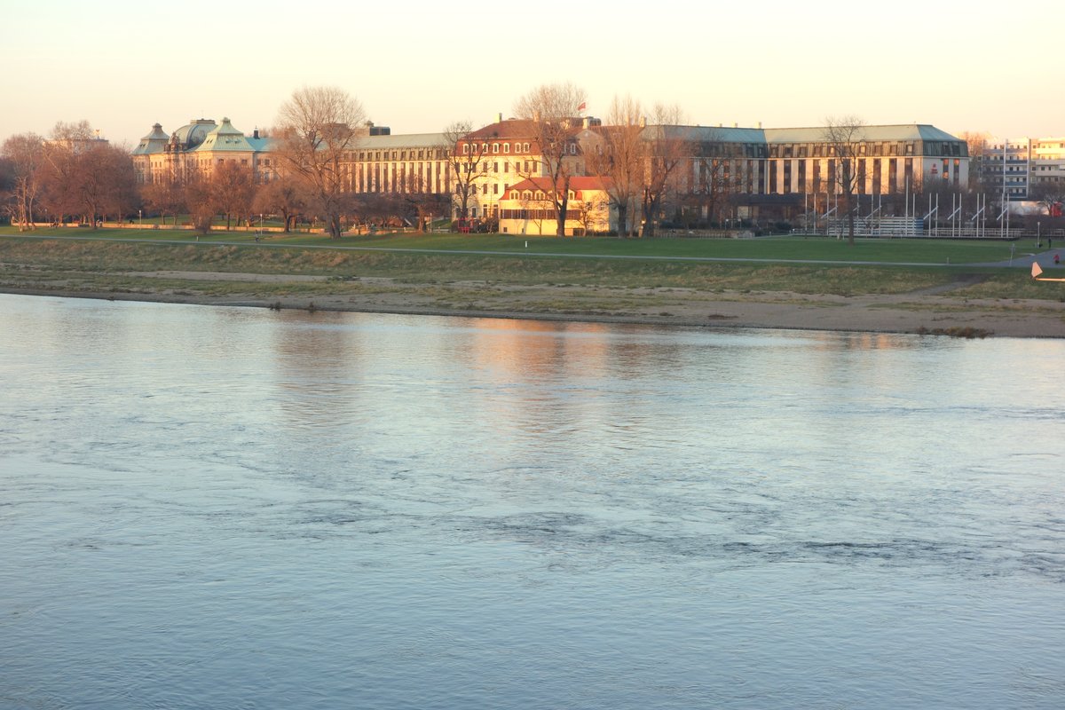 The Elbe River flowing through Dresden, Germany with cityscape and blue sky